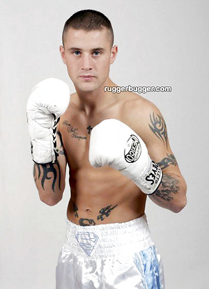 The heavily tattooed tough guy demurely stands on the scales covering his cock and balls