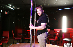 Mam dances in a night club around a pole and shows off his big dick